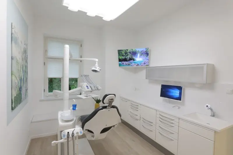 Behandlungszimmer mit digitalem Bildschirm und Zahnarztstuhl
